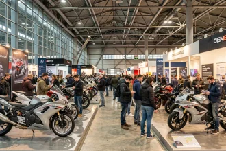 Hall d'exposition du salon EICMA à Milan avec des motos exposées et des visiteurs en train de découvrir les stands