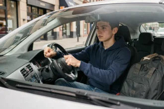 Jeune conducteur de 17 ans au volant d'une voiture citadine, illustrant la conduite sans permis avec le BSR