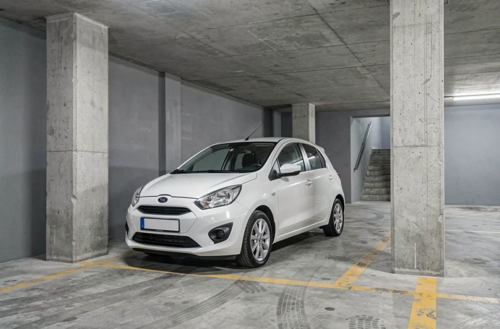 Voiture blanche stationnée dans un parking privé souterrain, contexte d'assurance véhicule remisé au garage